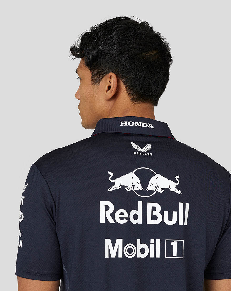 Back view of a man wearing a navy Red Bull Racing Teamline polo with a large white Red Bull and Mobil 1 logo on the back.