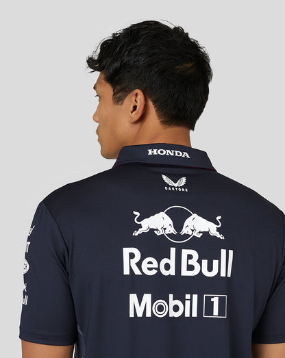 Back view of a man wearing a navy Red Bull Racing Teamline polo with a large white Red Bull and Mobil 1 logo on the back.