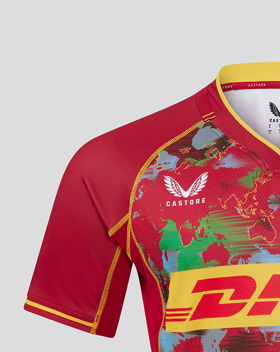 Shoulder and chest close-up of the red Harlequins shirt displaying world map print and collar branding.