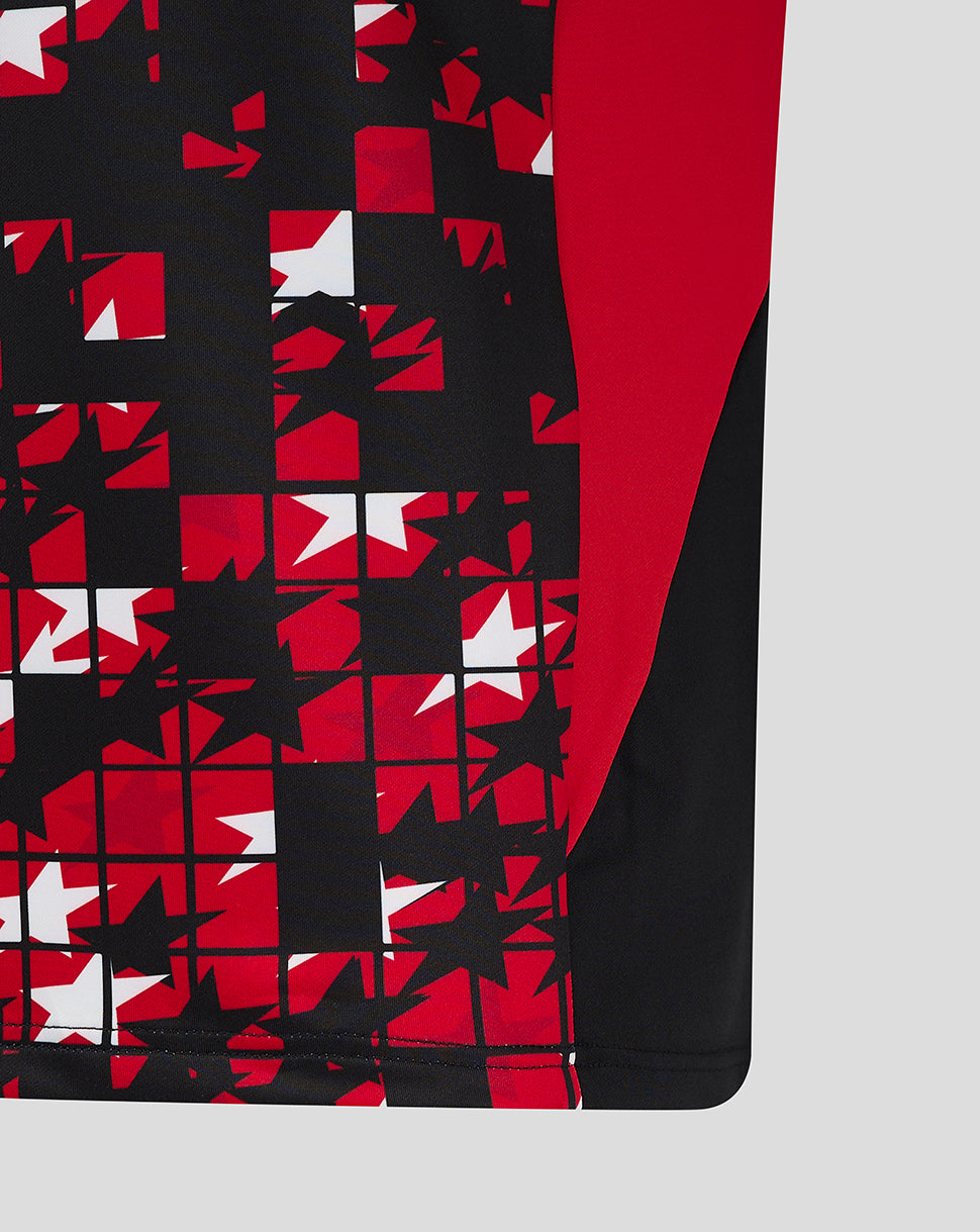 Lower front panel of the jersey with red white and black mosaic pattern on a black base.
