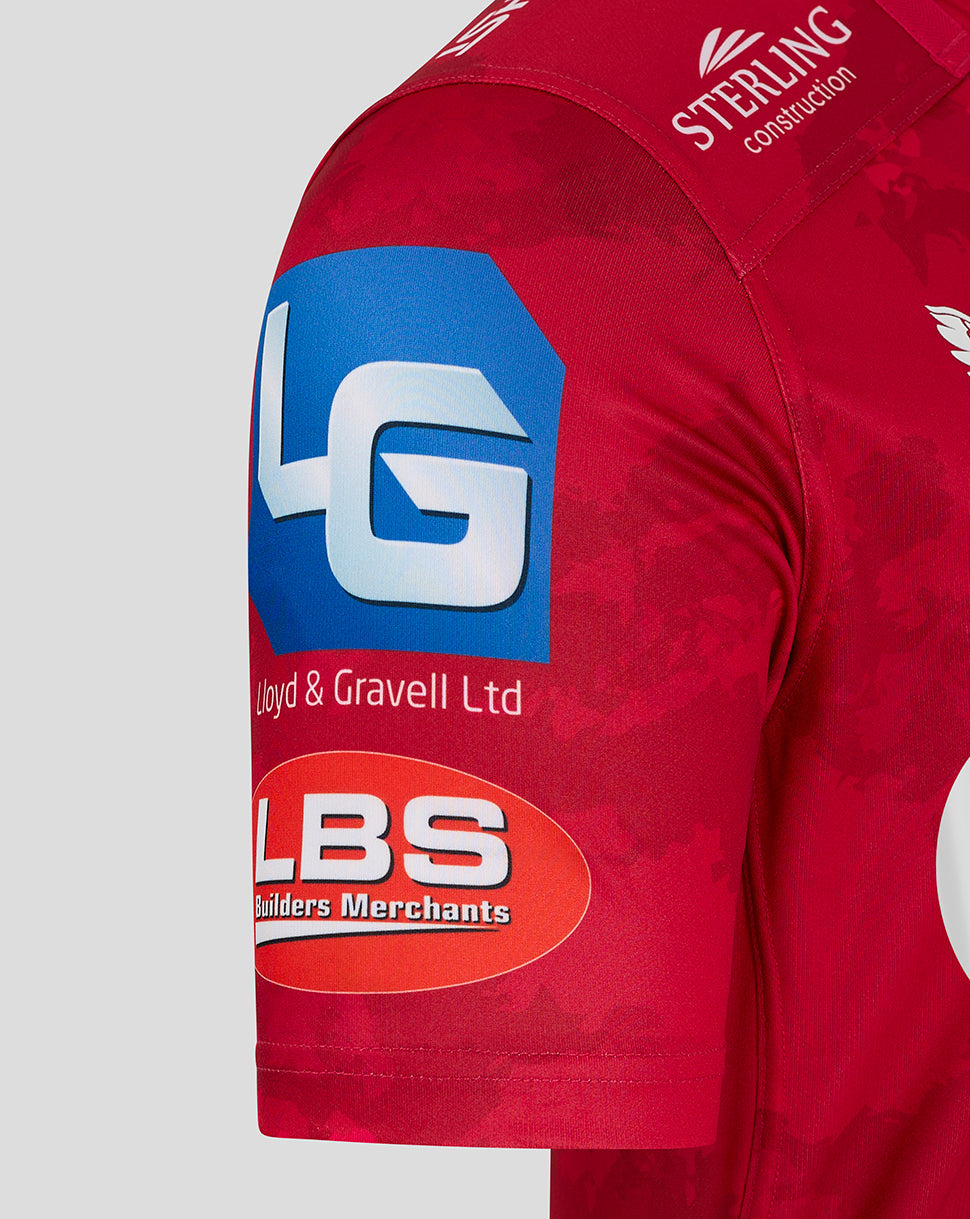 Close up of Scarlets home shirt sleeve showing blue LG sponsor patch Sterling Construction logo and Lloyd & Gravell Ltd branding on red fabric