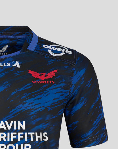Shoulder and chest area of Scarlets away shirt featuring Owens sponsor and red Scarlets crest on blue camo fabric.