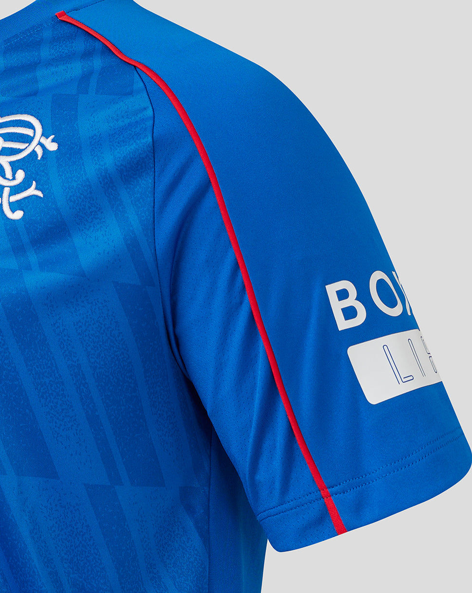 Close up of blue Rangers home shirt showing crest on left chest and red piping along the shoulder seam.