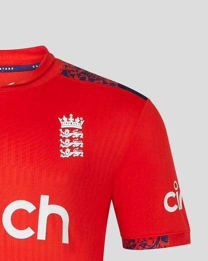 Close-up of upper front of red England men's Pro T20 shirt showing crest on chest and blue patterned sleeve trim