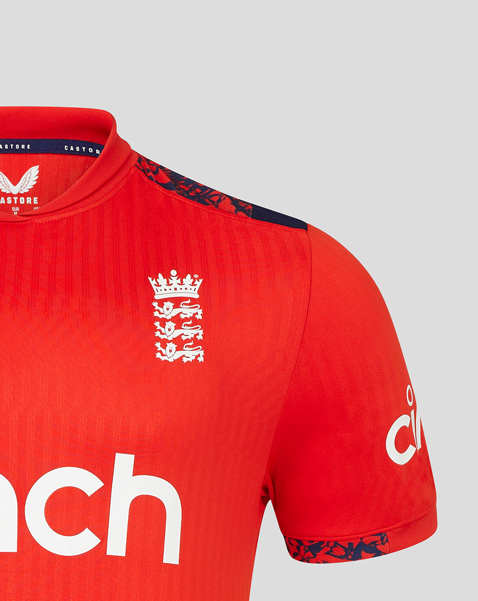 Close-up of red England cricket short sleeve T20 jersey showing left chest crest and bold cinch branding across the front