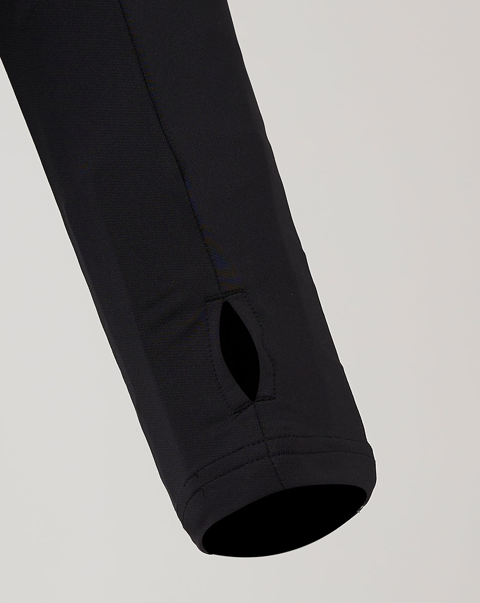 Sleeve lower with a small oval ventilation hole near the cuff on the black training top