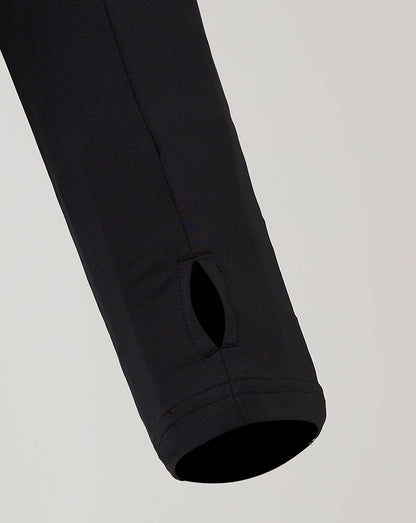 Sleeve lower with a small oval ventilation hole near the cuff on the black training top