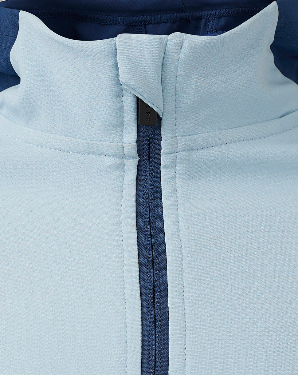 Close-up of the jacket zipper and collar area in light blue fabric with navy zipper detail