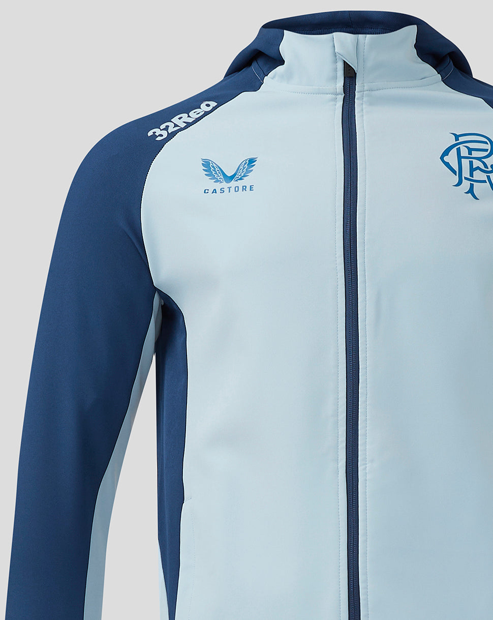 Chest close-up of Rangers Pro Players jacket with light blue body navy sleeves and crest on left chest and Castore logo on right.