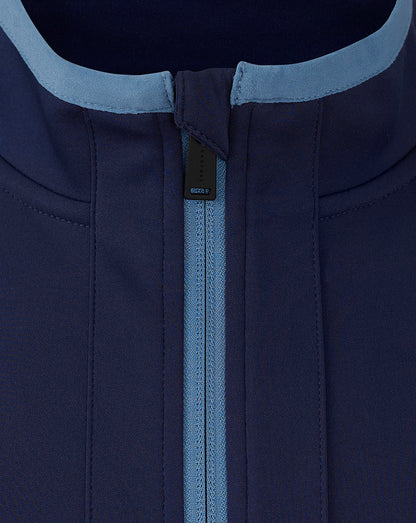 Close-up of the neck area showing light blue collar trim and center back zip detail on the navy travel jacket.