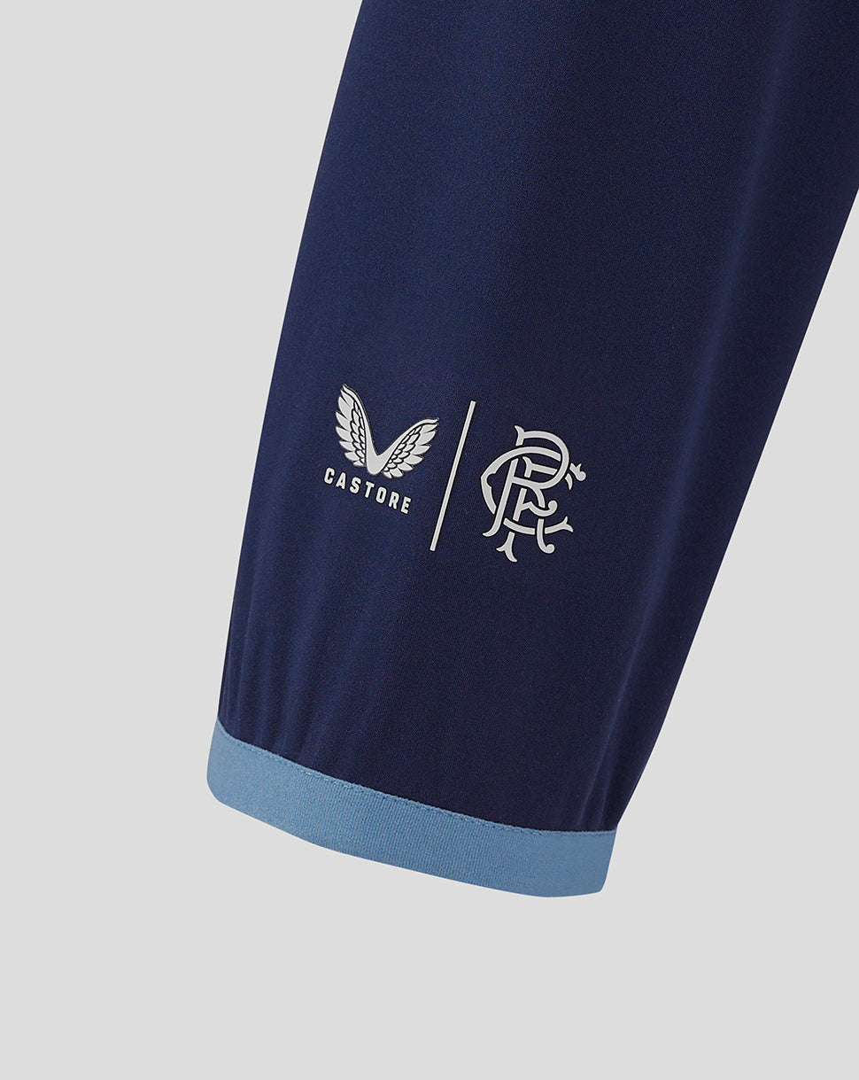 Close-up of sleeve cuff with light blue trim and Castore plus club crest on navy Rangers jacket.