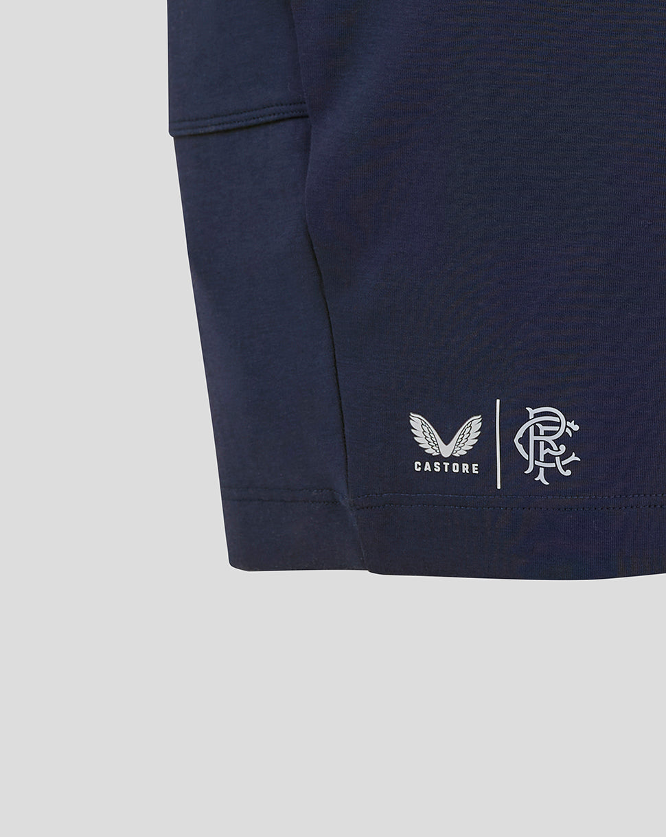 Close-up of navy Rangers FC shorts showing Castore logo and club crest near the leg area.