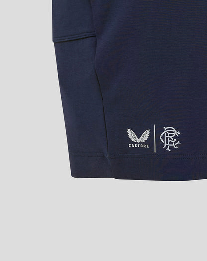 Close-up of navy Rangers FC shorts showing Castore logo and club crest near the leg area.