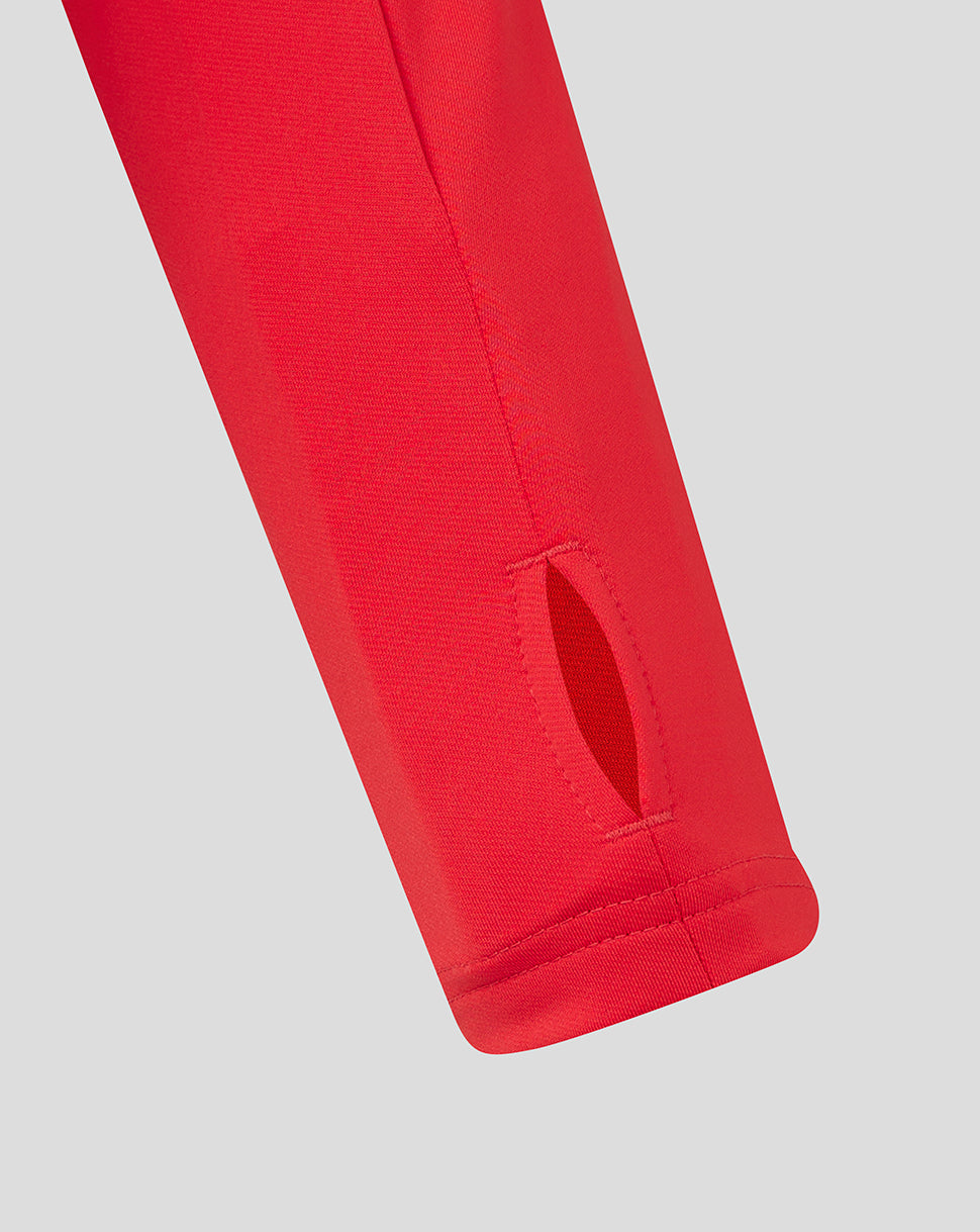 Red training top sleeve with a small vent slit at the cuff