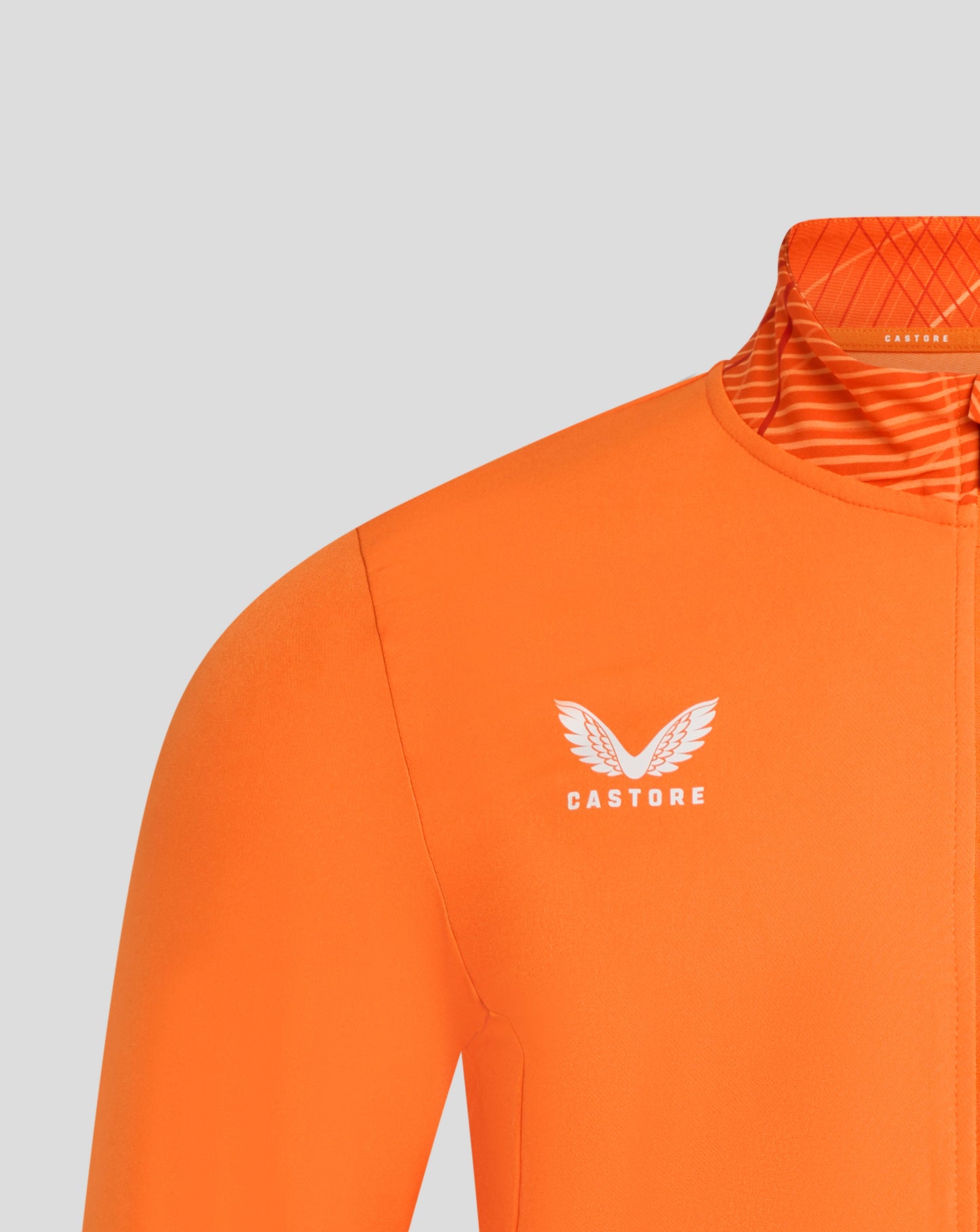 Close up of the orange jacket collar with geometric interior pattern and Castore branding.