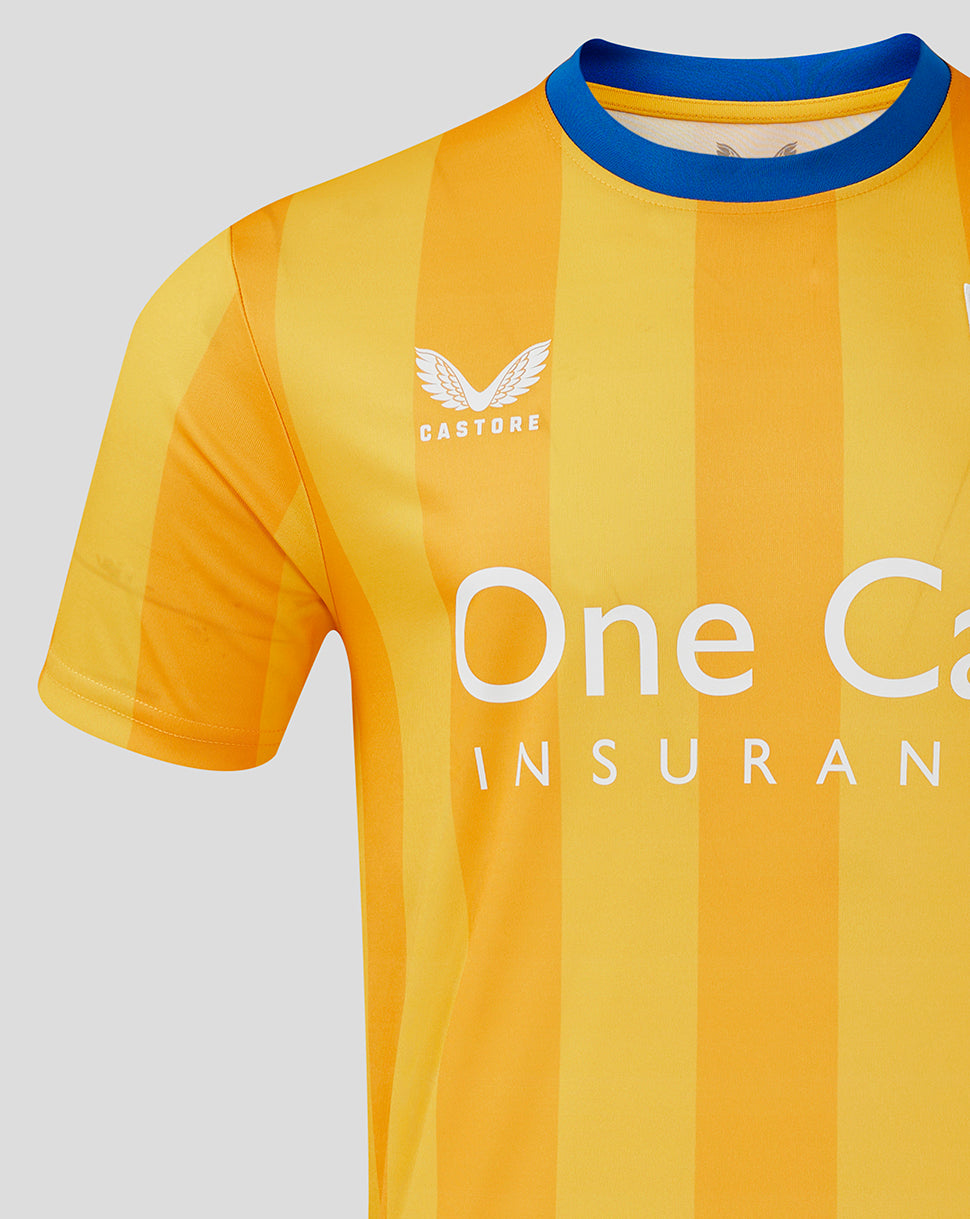 Close-up of Mansfield Home Shirt chest area showing crest on left and One Call Insurance across front with yellow striped pattern.