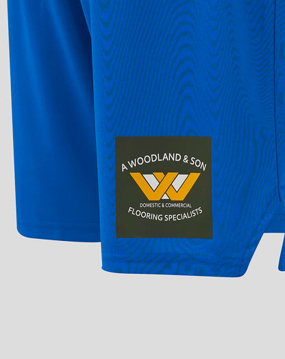 Blue Mansfield Home Shorts hem area with A Woodland & Son logo patch