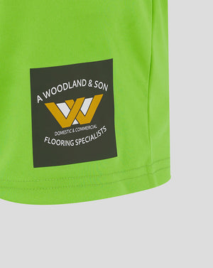 Close-up of bright green Mansfield Away goalkeeper shorts with crest on left leg and Castore logo on right leg.