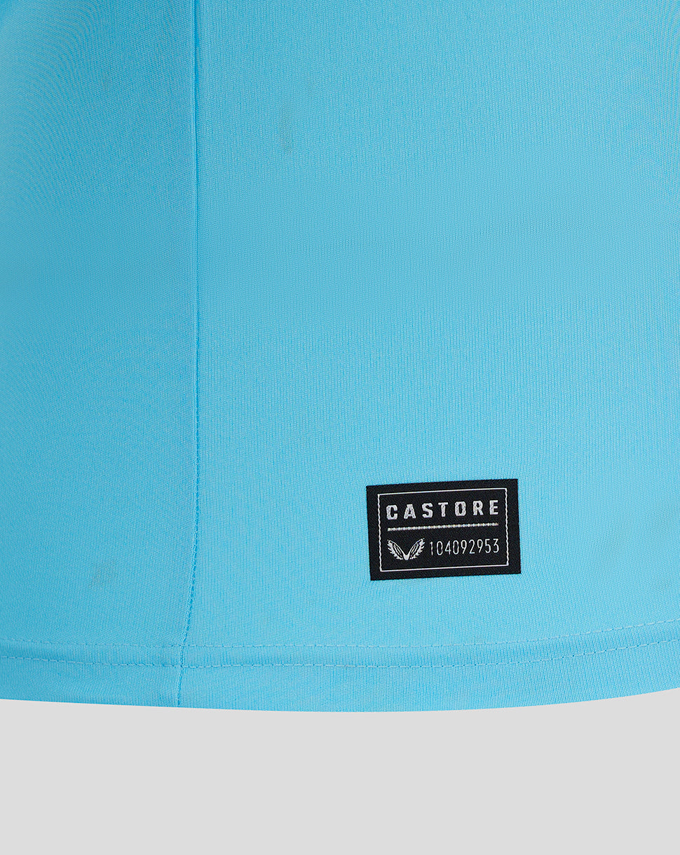 Close-up of turquoise Mansfield goalkeeper shirt fabric with a Castore patch at the hem