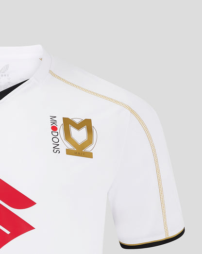 Front view of white MK Dons home shirt with bold red sponsor graphic and club crest on the chest