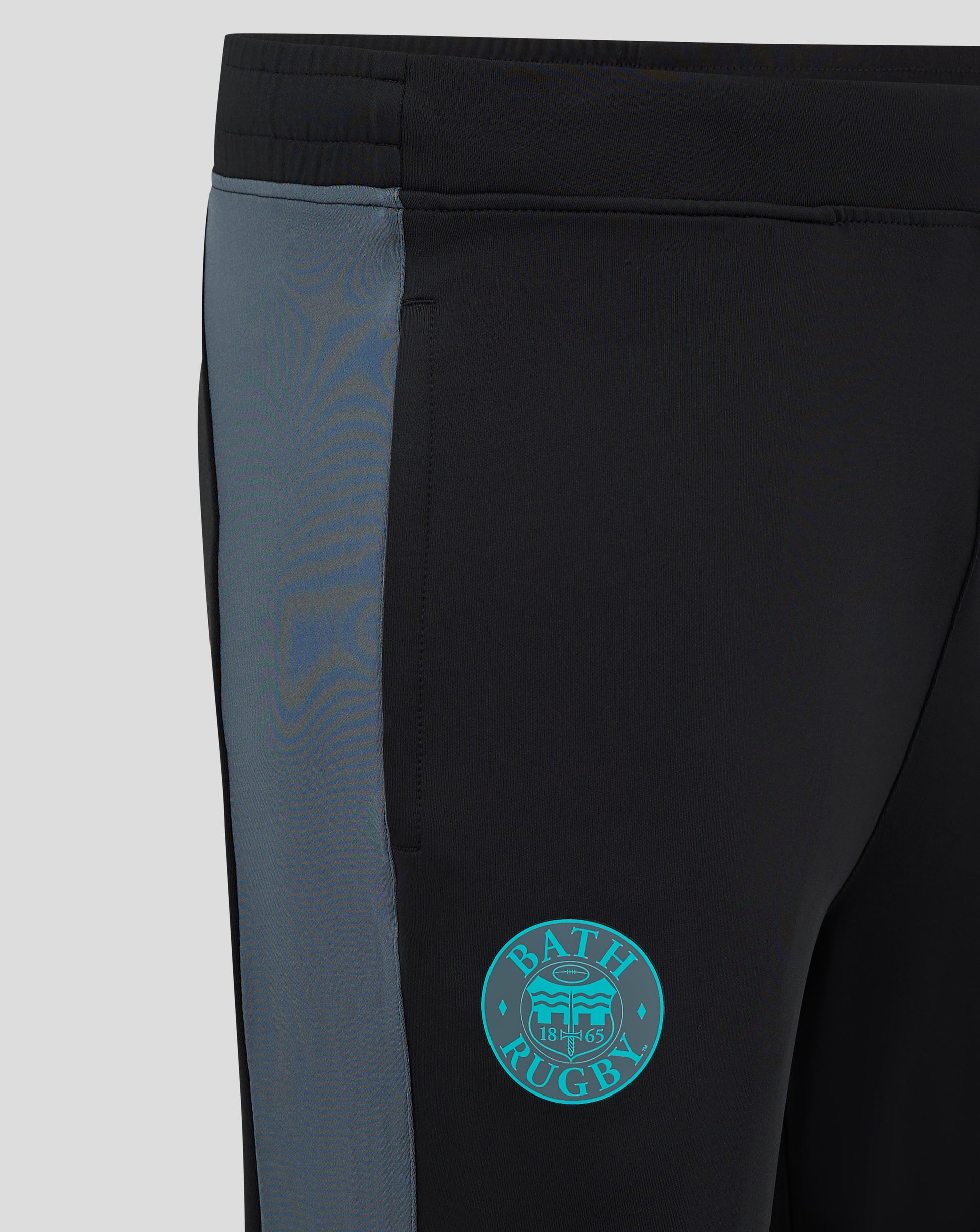 Close-up of Bath Rugby Pro Players training pants showing black fabric with blue side panel and Bath Rugby crest on the thigh