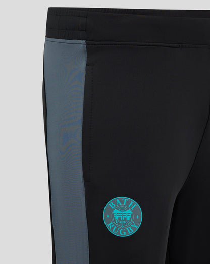 Close-up of Bath Rugby Pro Players training pants showing black fabric with blue side panel and Bath Rugby crest on the thigh