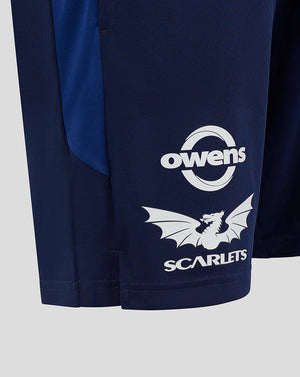 Close up of left leg showing Owens circular logo and dragon Scarlets graphic on navy fabric.