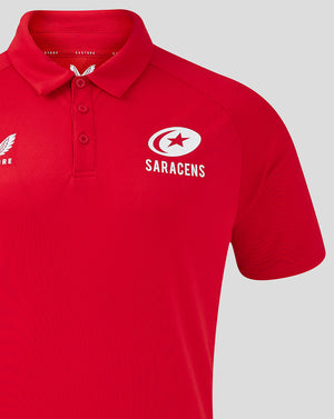 Close-up of red polo showing Castore logo on the left chest and Saracens logo on the right chest.