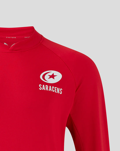 Close up of white Saracens crest on red training top near the shoulder