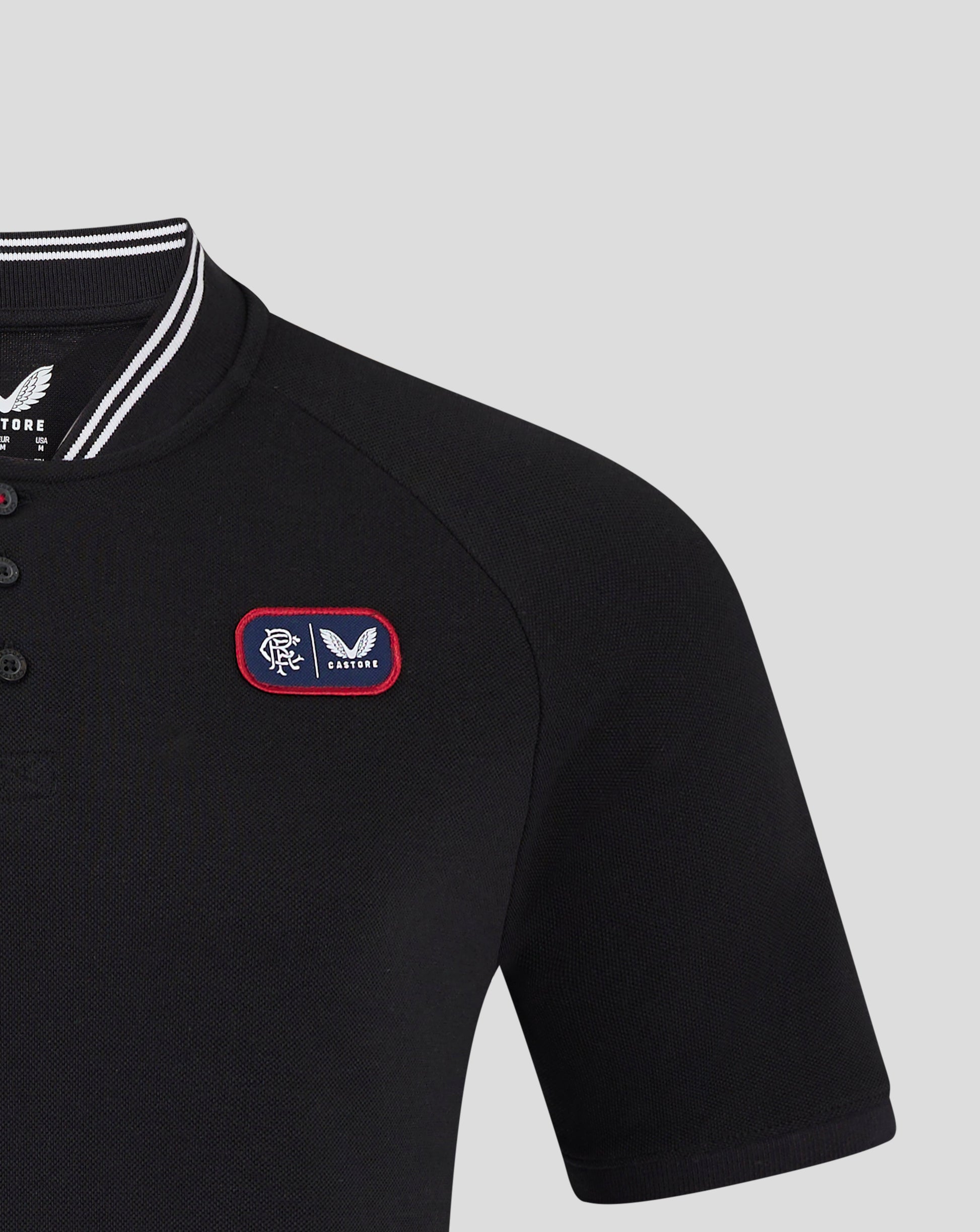 Close-up of black Rangers polo showing bomber collar with white stripes and front chest badge