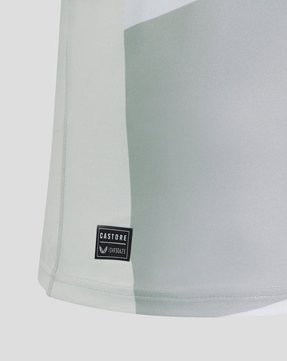 Close-up of pale grey fabric with Castore logo patch near the hem of the Saracens away shirt.