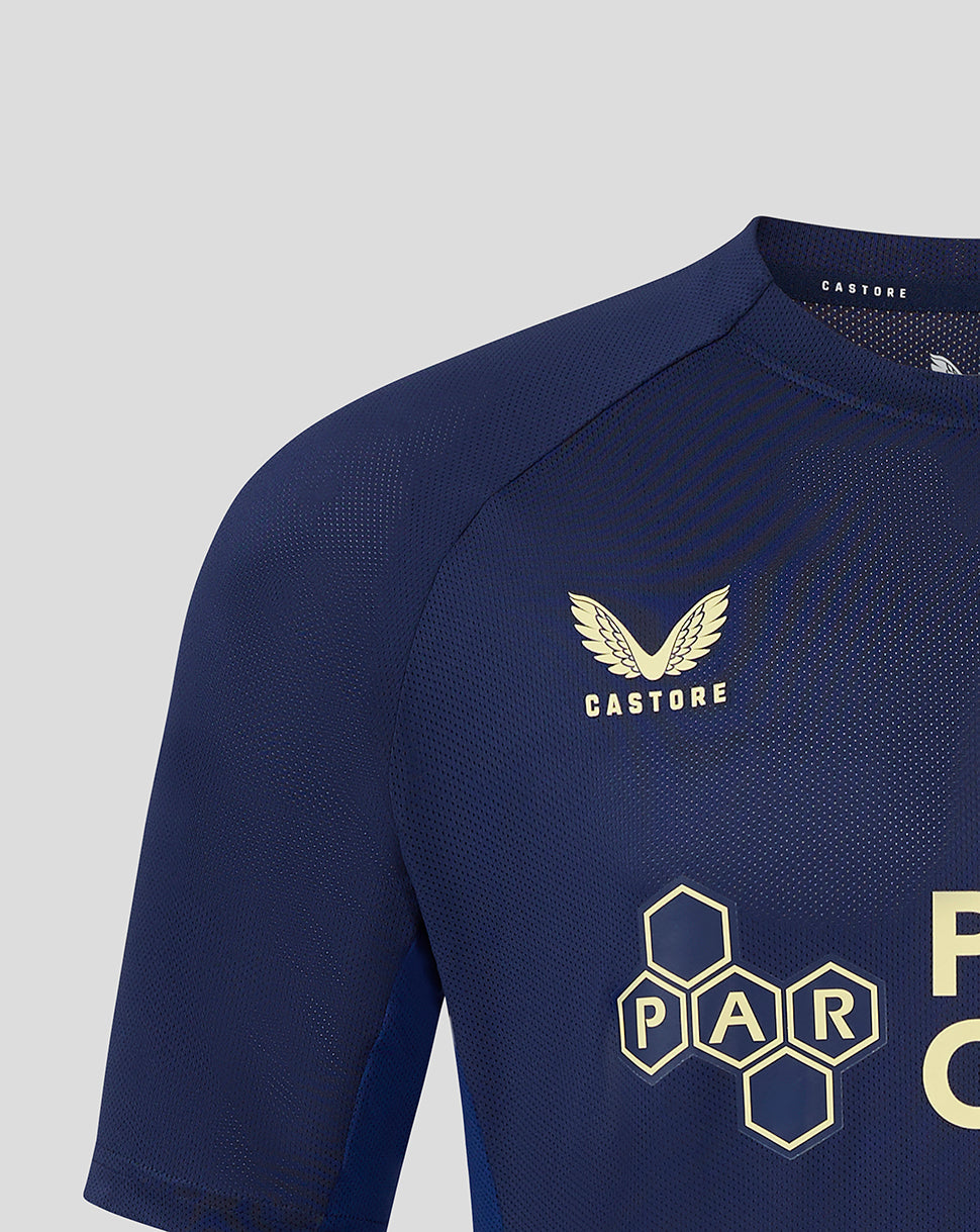Navy junior training T shirt close up showing left chest club crest and Castore branding at the neckline