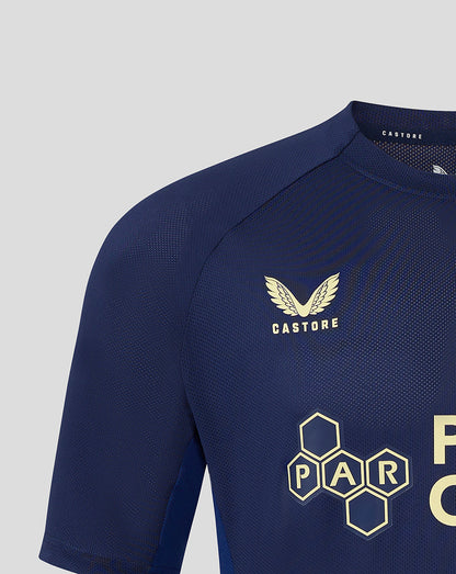 Navy junior training T shirt close up showing left chest club crest and Castore branding at the neckline