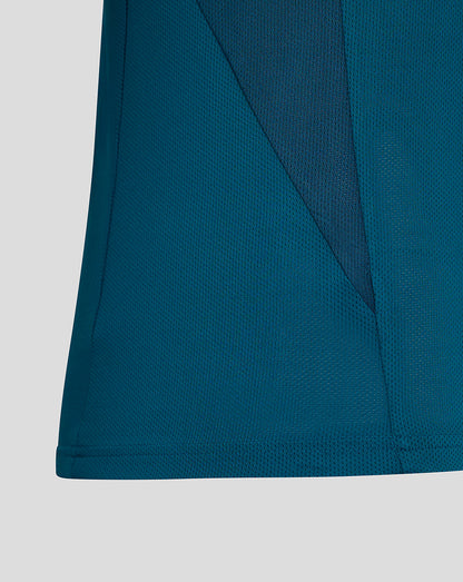 Close up of teal fabric at the shirt hem and side seam details.