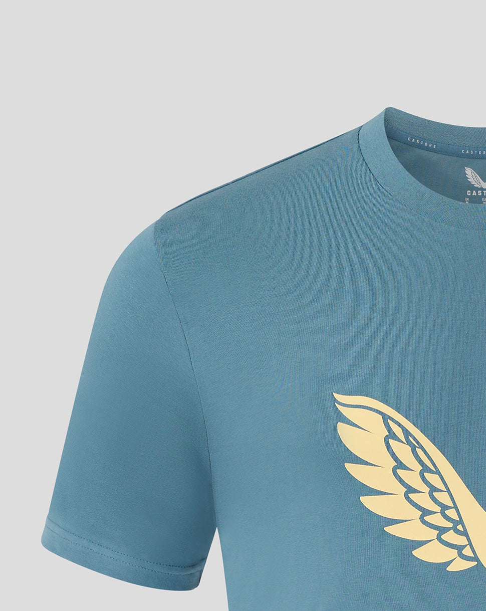 Close-up of pale gold wing logo on chest of light blue Mansfield Town training tee.