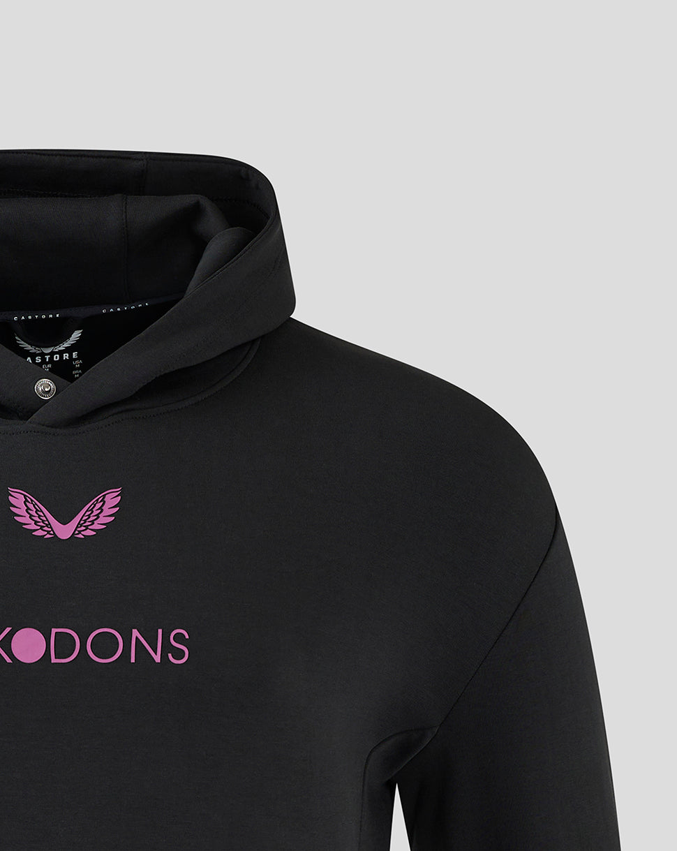 Close up of front of black hoody with pink MK DONS lettering and wing emblem