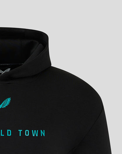 Close-up of the black Mansfield Town hoodie showing teal crest at the shoulder and teal lettering across chest