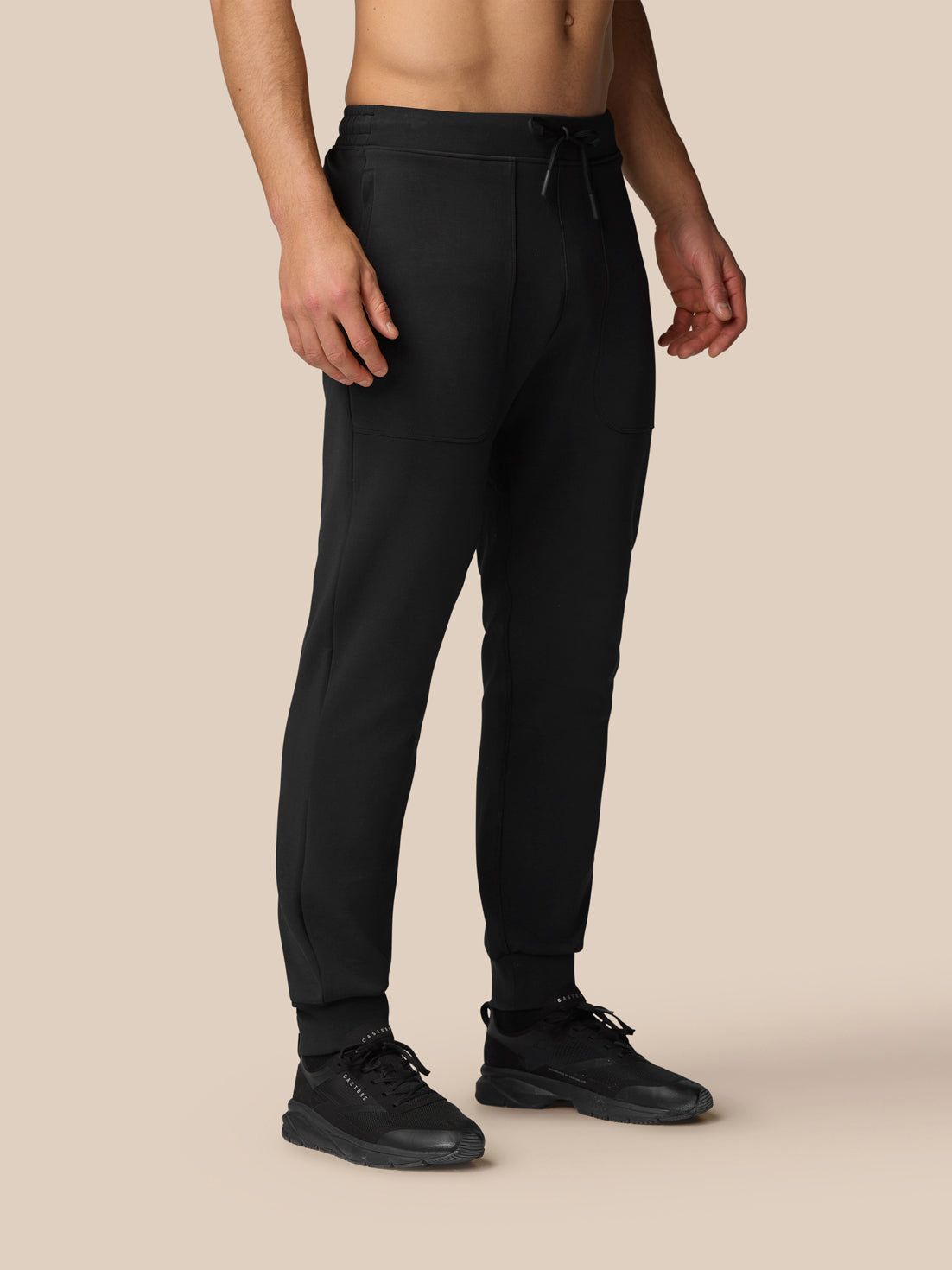 Model wearing black Flex Travel Joggers with a drawstring waist and Castore branding on the thigh