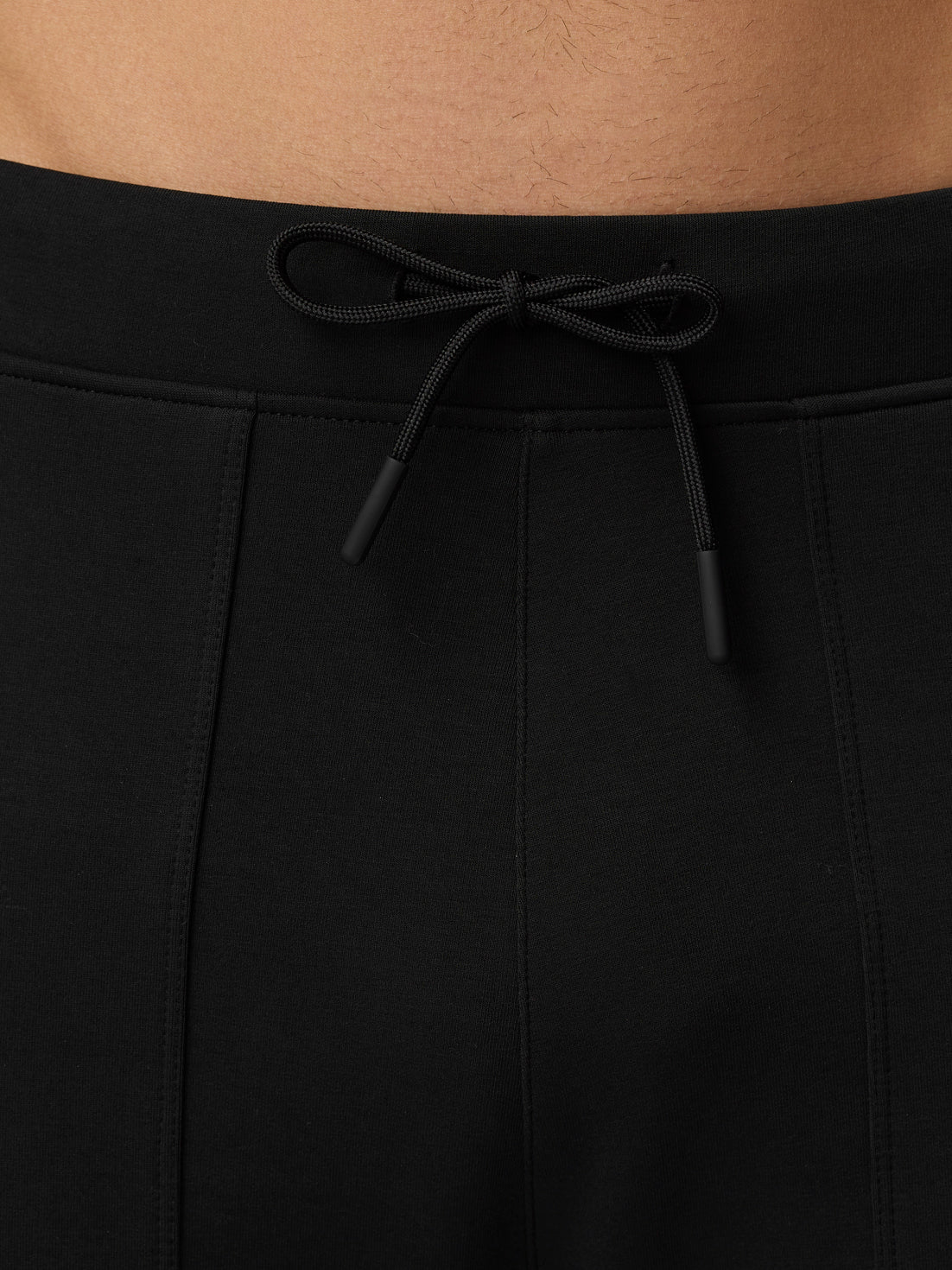 Back view of black Flex Travel Joggers waistband with external drawstrings tied.