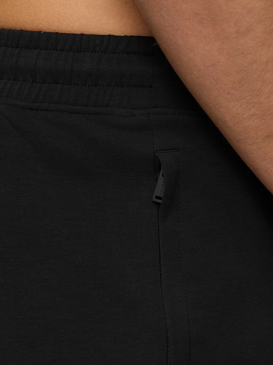 Close-up of black Flex Travel Joggers hip area with a vertical zip pocket.