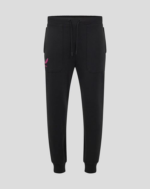 Front view of black Mk Dons travel pant with a drawstring waistband and a pink logo on the left thigh