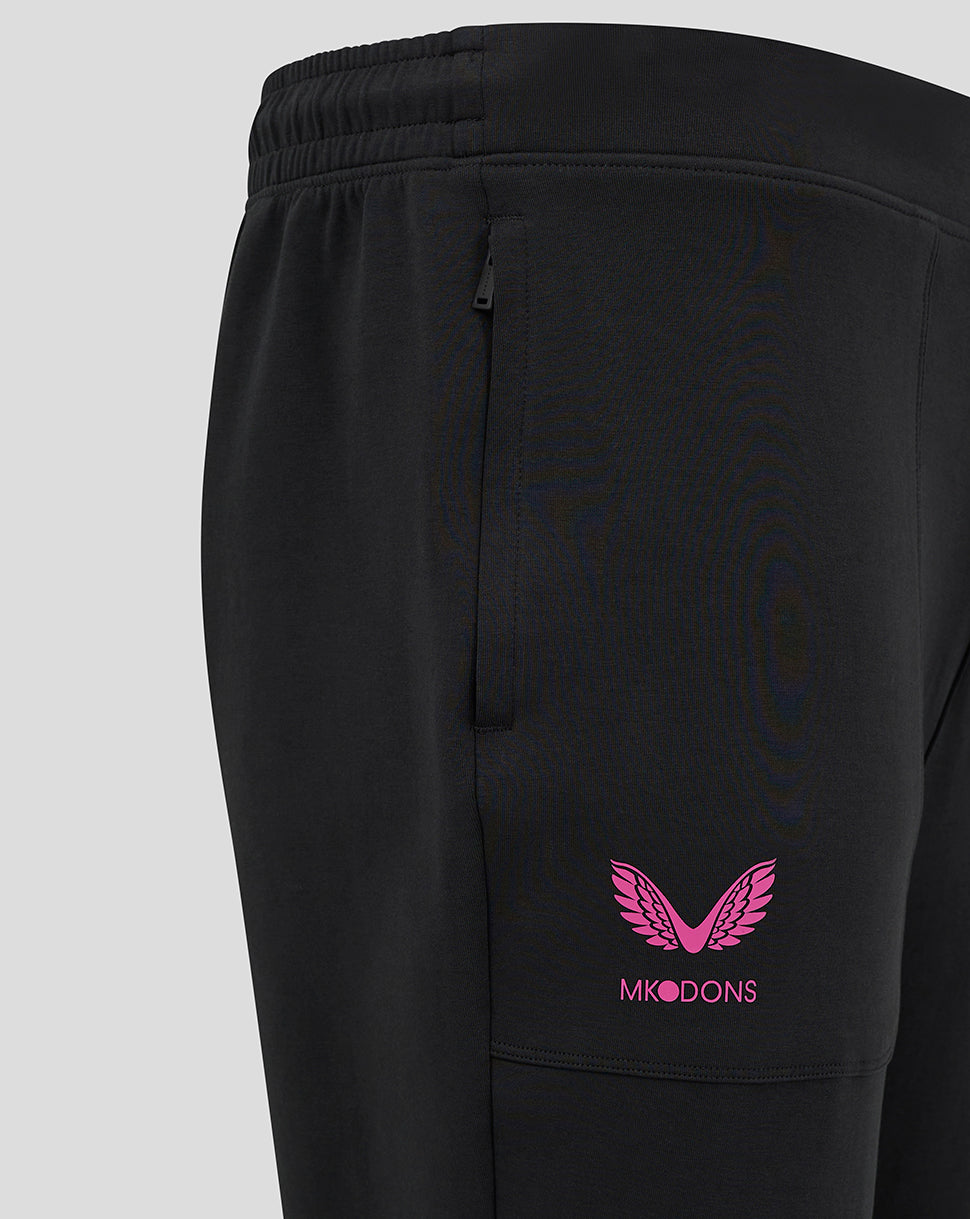 Close up of black Mk Dons travel pant showing side pocket and pink Mk Dons logo on the thigh.