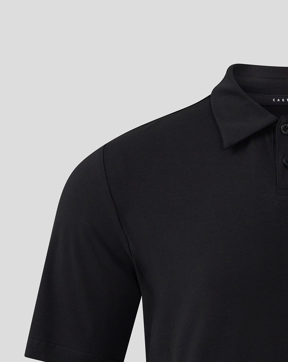 Close-up of black polo shoulder and collar with brand Castore label visible inside.