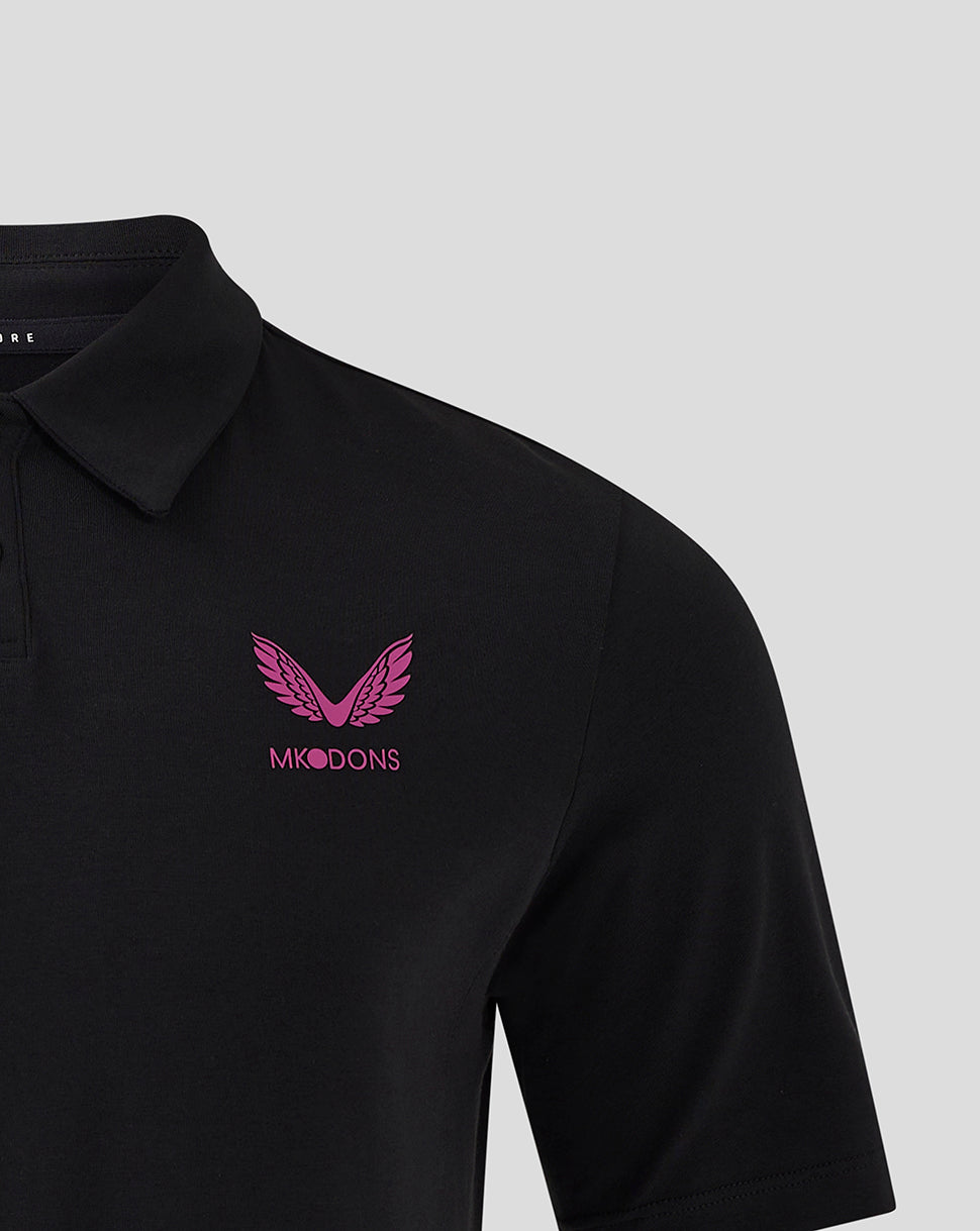 Black polo with pink MK DONS logo and wing emblem on the left chest.