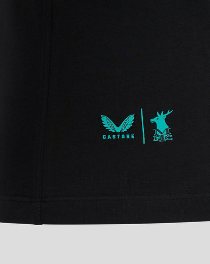 Close-up of black Mansfield Travel Polo hem with turquoise Castore logo and deer crest