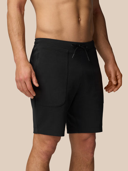 Black Travel Shorts with drawstring waistband and side pockets worn by a model.
