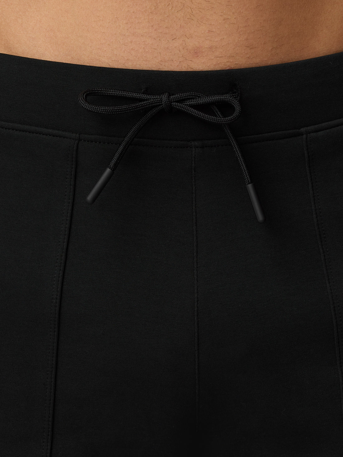 Close-up of the adjustable black drawstring at the waistband of travel shorts.