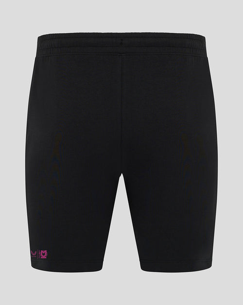 Back view of black Mk Dons travel shorts with pink logo near the hem