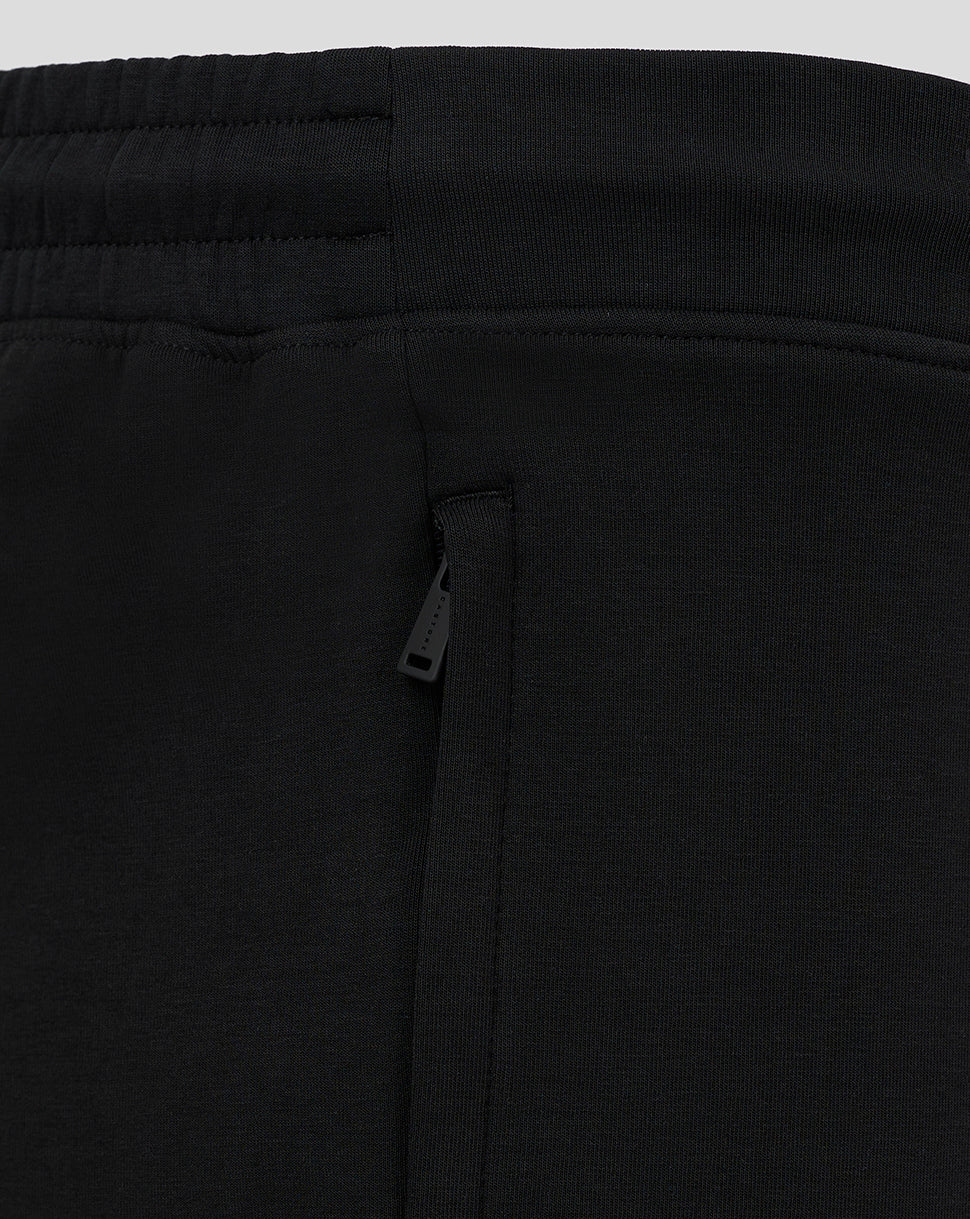 Close-up of the waistband and side zip pocket on black travel shorts.