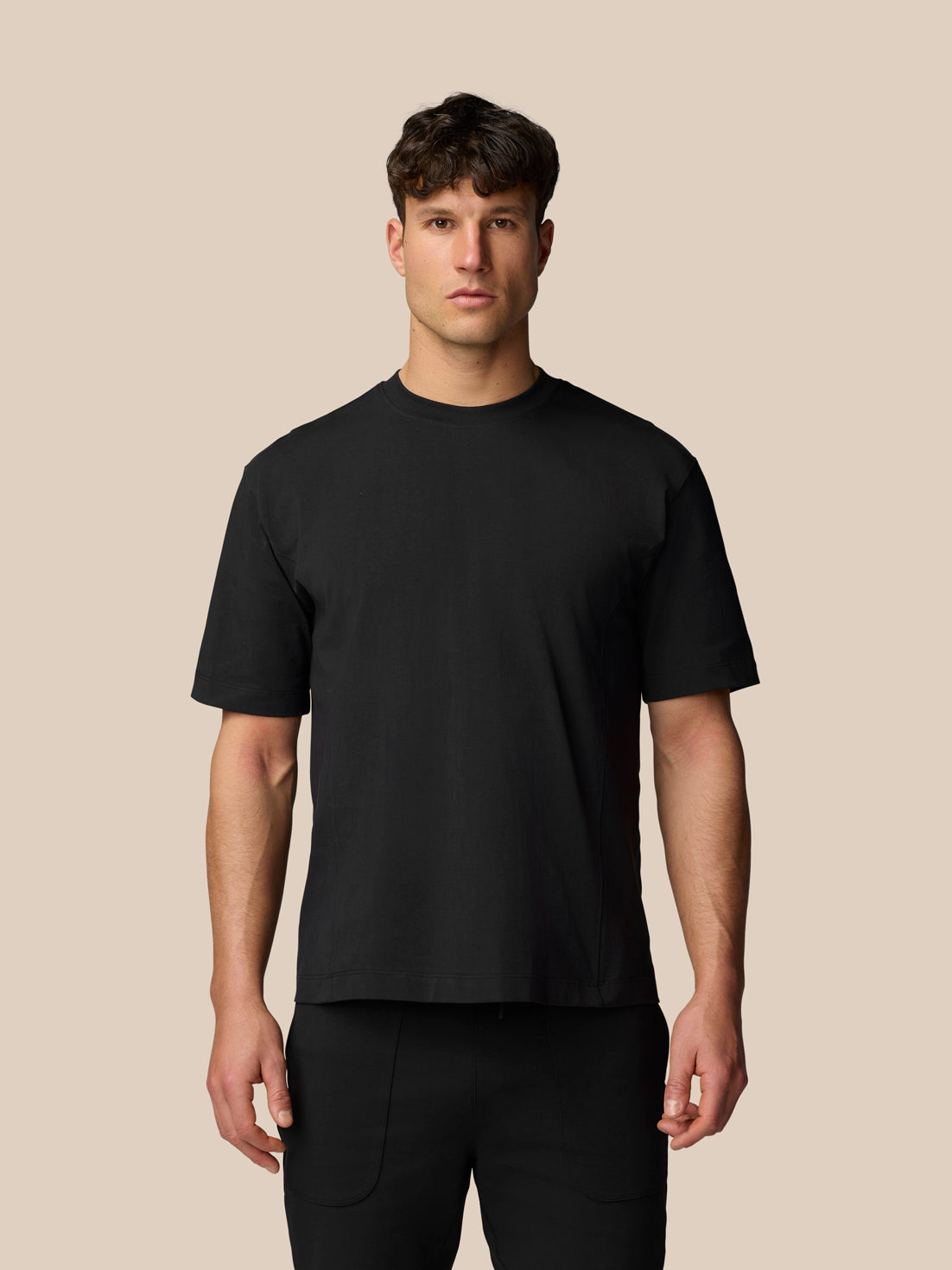 Male model wearing black Travel T Shirt in relaxed fit